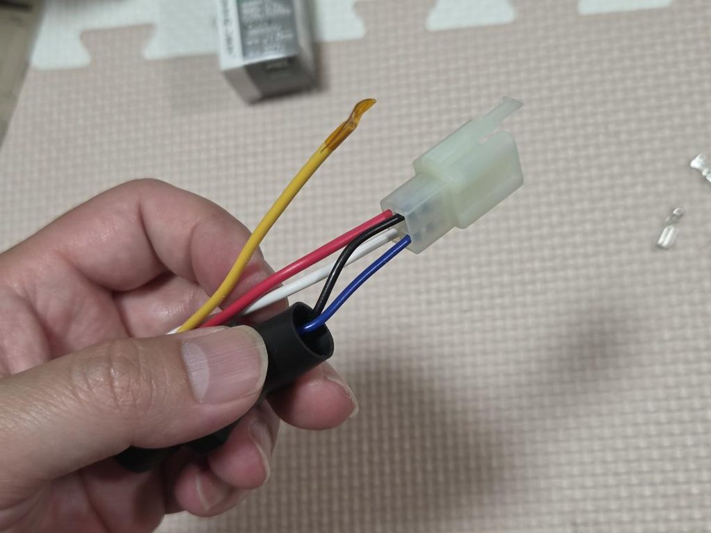 圧着した端子を4極カプラーのオス側ハウジングへ差し込んだリレーユニット