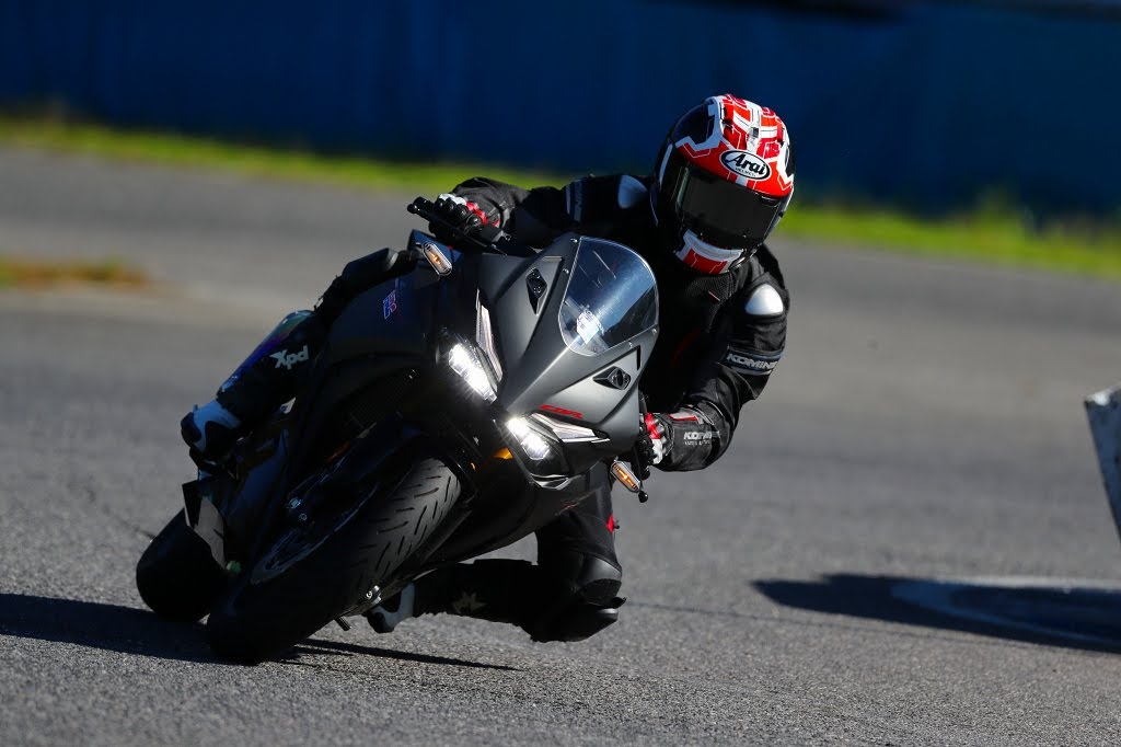 サーキットのコーナーをフルバンクで攻めるCBR250RRの走行シーン