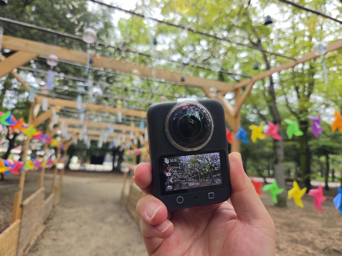 風鈴が並ぶ屋外通路でDJI Osmo 360を手持ちしている様子