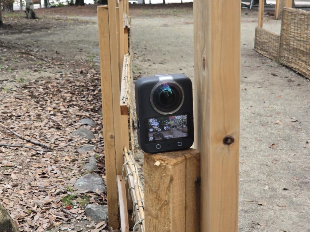 公園の木製フェンスに置いてパノラマ撮影を準備するDJI Osmo 360