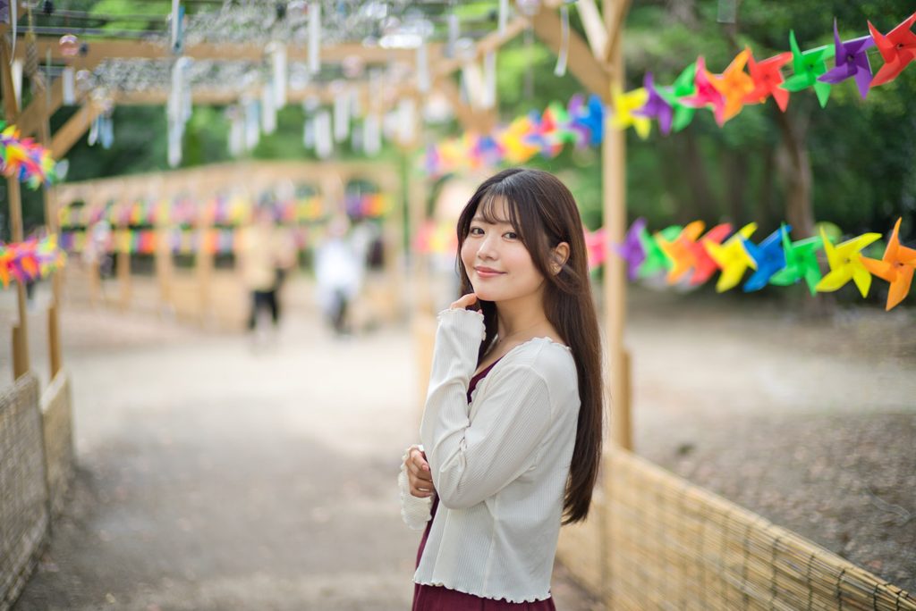 風車を背景にした桜井こはるさんのバストアップポートレート(開放F1.0)
