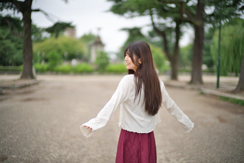 両手を広げて振り返る桜井こはるさんの動きあるポートレート(開放F1.0)