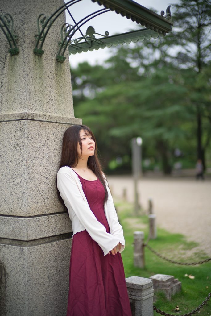 噴水塔西側の石柱にもたれる桜井こはるさんのポートレート(開放F1.0)