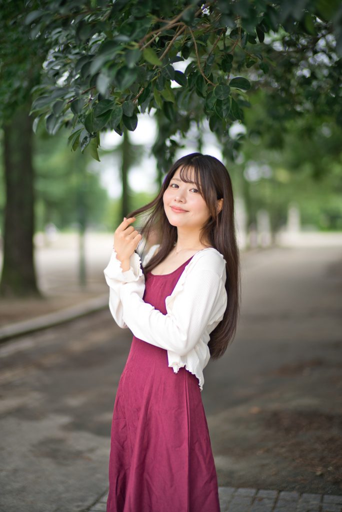 前ボケの葉と並木道に佇む桜井こはるさんのポートレート(開放F1.0)