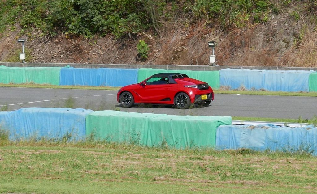 幸田サーキットのバックストレートを全開走行する赤いS660