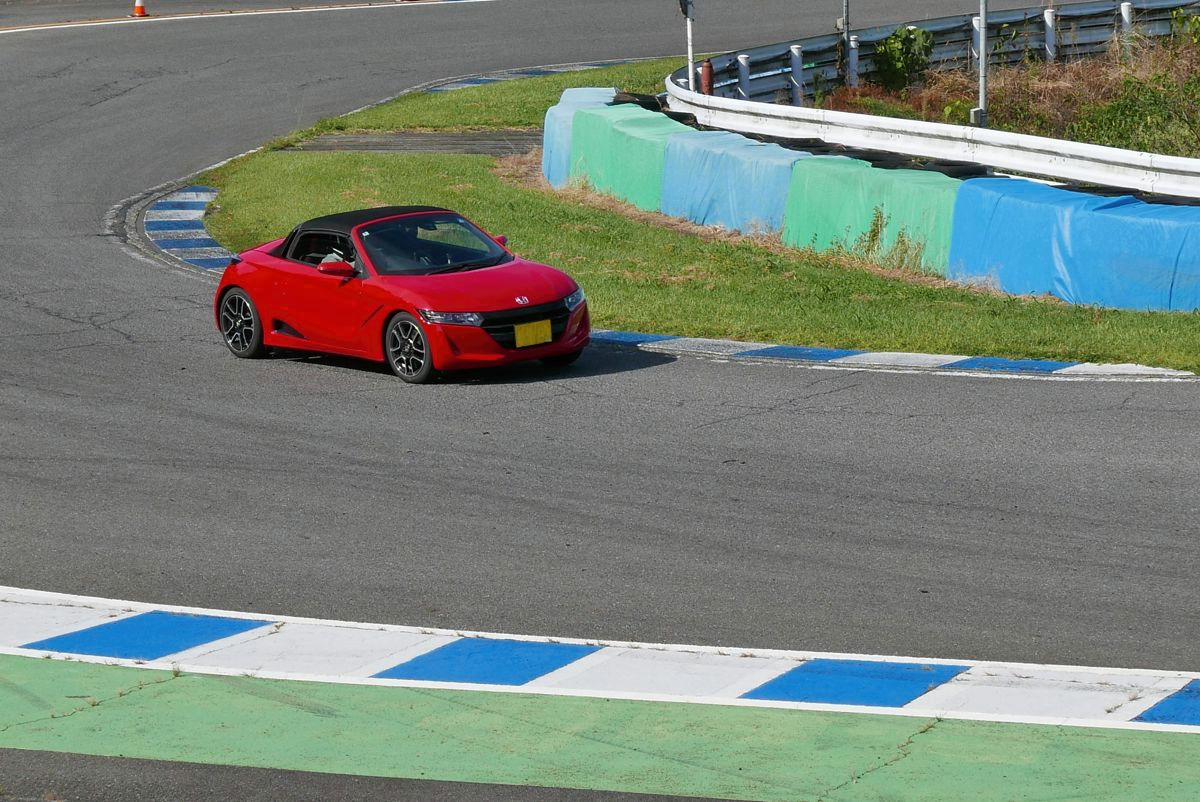 幸田サーキットの縁石に沿ってコーナーを旋回する赤いS660