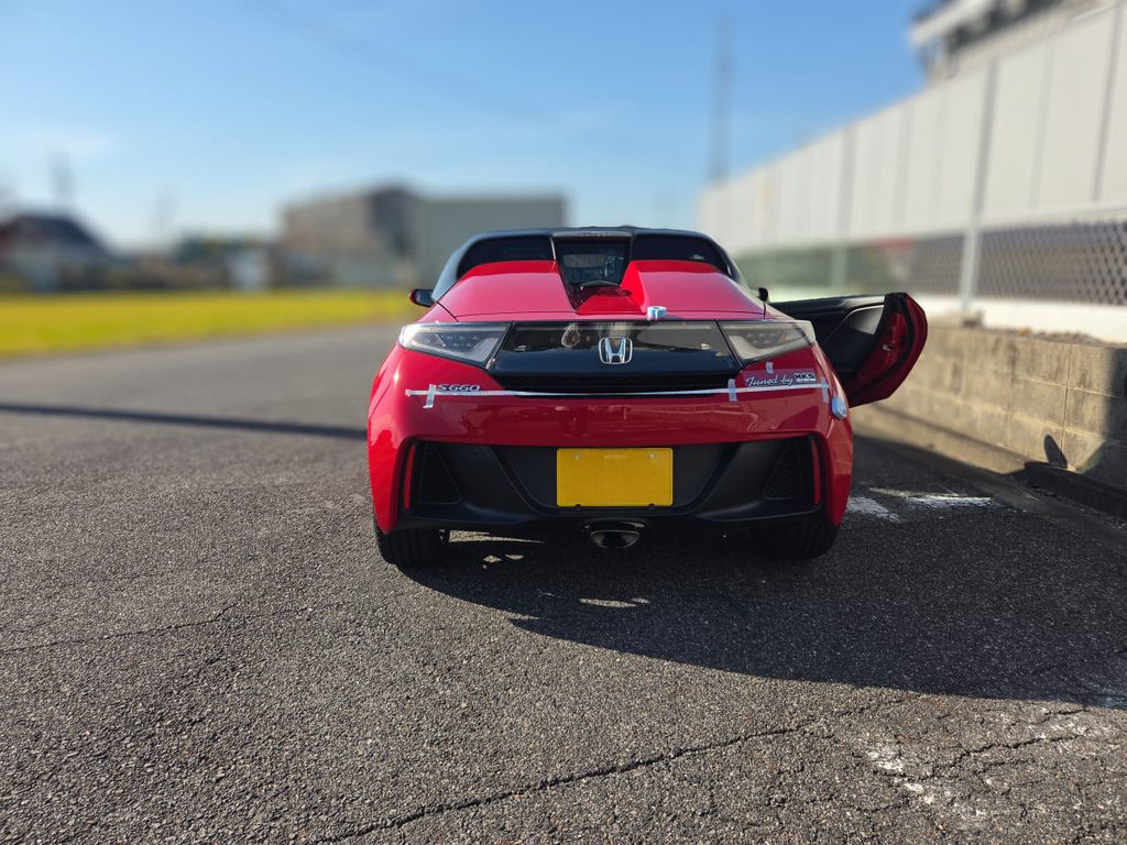メジャーとマスキングテープでリアの位置出し作業を行う赤いS660